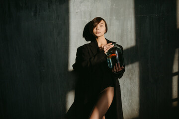 Asian womanl with an aquarium fish in a dark room.