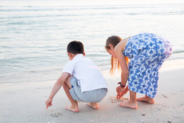 Young Brother and Sister Playing on Beach 