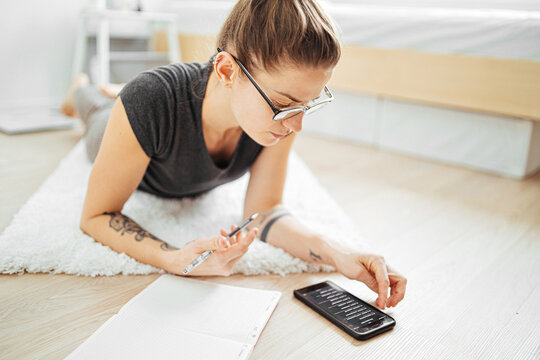 young brunette transmits text from notebook to smartphone
