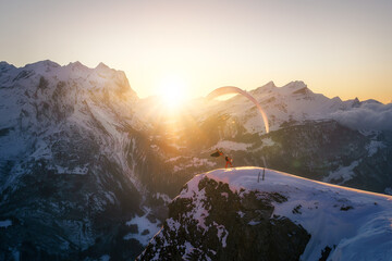 SKier and paraglider high five