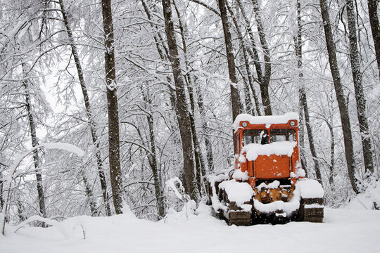 Abandoned tractor in a snowy forest