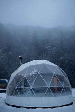 Exterior of spherical glamping cupola in winter snowy forest