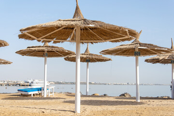 Beautiful beach scene with palm trees and perfect blue sea water. view of an empty beach with white beach umbrellas and turquoise clear water