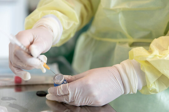 Drawing vaccine out of a canister - Powered by Adobe