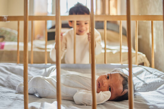 The older brother looks at his little newborn sister.