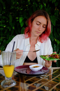 Girl with red hair eats falafel