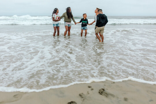 Black family wading in ocean