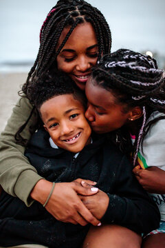 Mother embracing son and daughter at beach