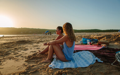 Two friends sitting on the beach