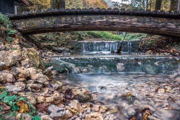 Fototapeta premium Close up view of waterfall in the forest and bridge over river. Samoborsko gorje, summer in Croatia.