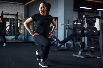 Fototapeta na wymiar Energetic young woman doing legs training in gym