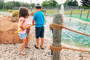 Kids trying to retrieve their lost ball from a pond. 
