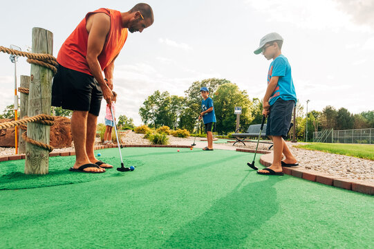 Adult male lining up his golf shot.
