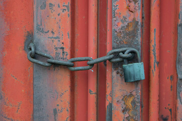 Old red container with a lock on a chain