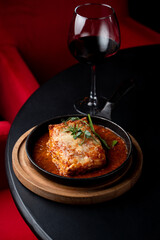 Classic ground beef lasagna with tomato sauce in a hot cast iron pan, posh fancy restaurant, top view for an expensive and elegant commercial