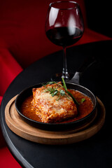 Classic ground beef lasagna with tomato sauce in a hot cast iron pan, posh fancy restaurant, top view for an expensive and elegant commercial