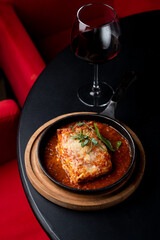 Classic ground beef lasagna with tomato sauce in a hot cast iron pan, posh fancy restaurant, top view for an expensive and elegant commercial