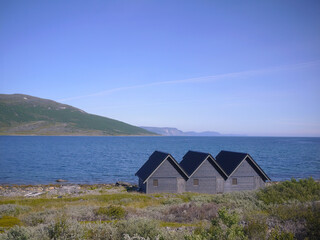 Fototapeta na wymiar Three small houses in Arctic Circle Scandinavia