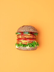 Veggie burger top view isolated on an orange background.