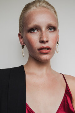 Model wearing red top and earrings