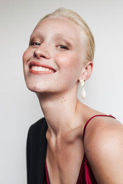 Model wearing red top and earrings