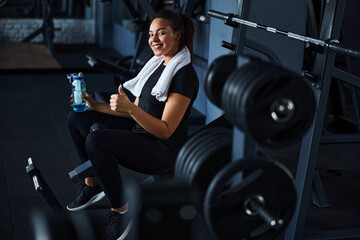 Smiling pretty woman feeling happy after gym workout