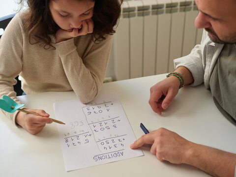 Father teaching girl maths at home