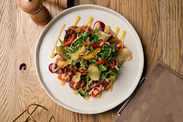 Delicious restaurant salad with mixed greens, roasted meat and a glass of good wine