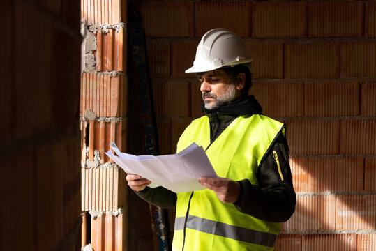 Inspector checking blueprint of new building