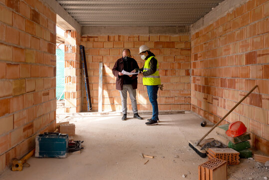 Foreman and customer discussing draft in building under construction