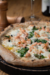 Close up of seafood pizza with chopped prawns and basil leaves, golden crust, appetizing photo