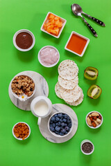 Healthy breakfast Charcuterie Boards - granola, yogurt, fruits and berries variety, nuts and flakes on the bright summer background