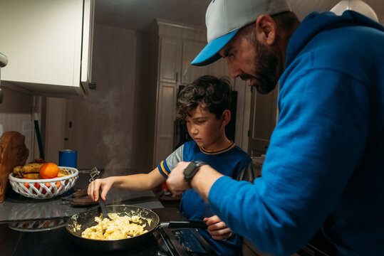 Father and son cooking together. 
