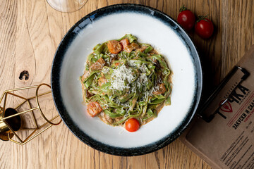 Vegetarian tagliatelle in an italian restaurant, wooden table, menu photography set