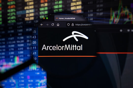 ArcelorMittal company logo on a website with blurry stock market developments in the background, seen on a computer screen through a magnifying glass	