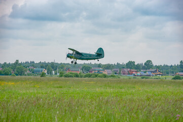 Military light aircraft An 2 takes off from the field above the village