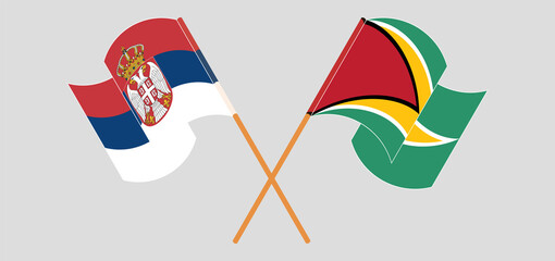 Crossed and waving flags of Serbia and Guyana