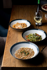 An assortment of different traditional italian meals: risotto, ground beef penne and vegetable pasta
