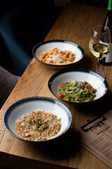 An assortment of different traditional italian meals: risotto, ground beef penne and vegetable pasta
