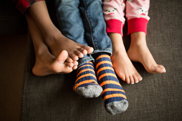 Sibling feet snuggled together on couch