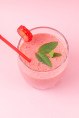 Strawberry milkshake with mint on a pink background. Healthy eating for breakfast and snacks