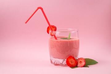 Strawberry milkshake with mint on a pink background. Healthy eating for breakfast and snacks
