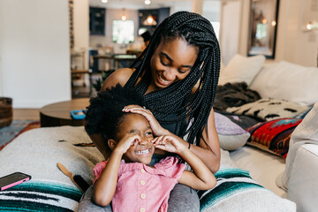 A mother fixing her daughter's hair. Hair care for kids. 