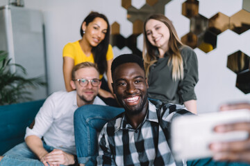 Smiling black man with friends taking selfie