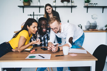 Positive diverse colleagues browsing smartphone