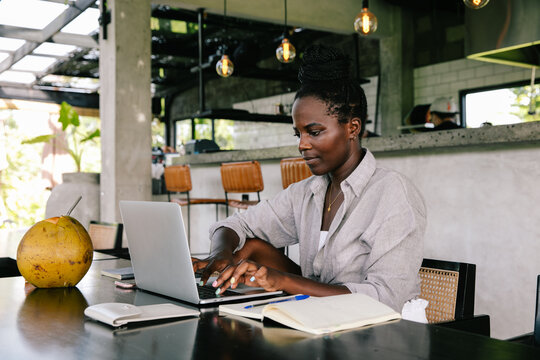 Young Black Woman Working Remotely from Restaurant