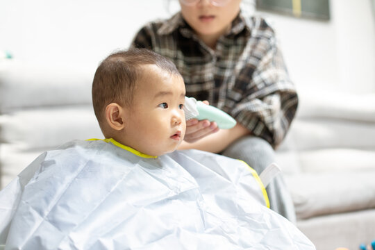 Little boy has his hair cut at home