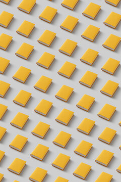 Pattern of yellow papercraft books on gray background