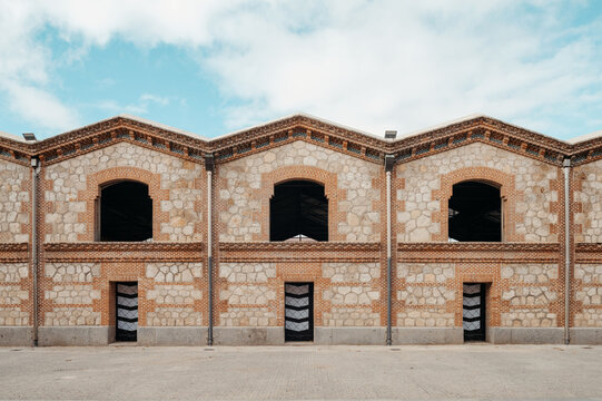 Symmetric brick wall with decorated tile outdoors.