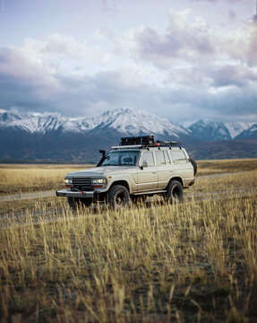 Vintage offroad suv on mountain valley background in autumn.